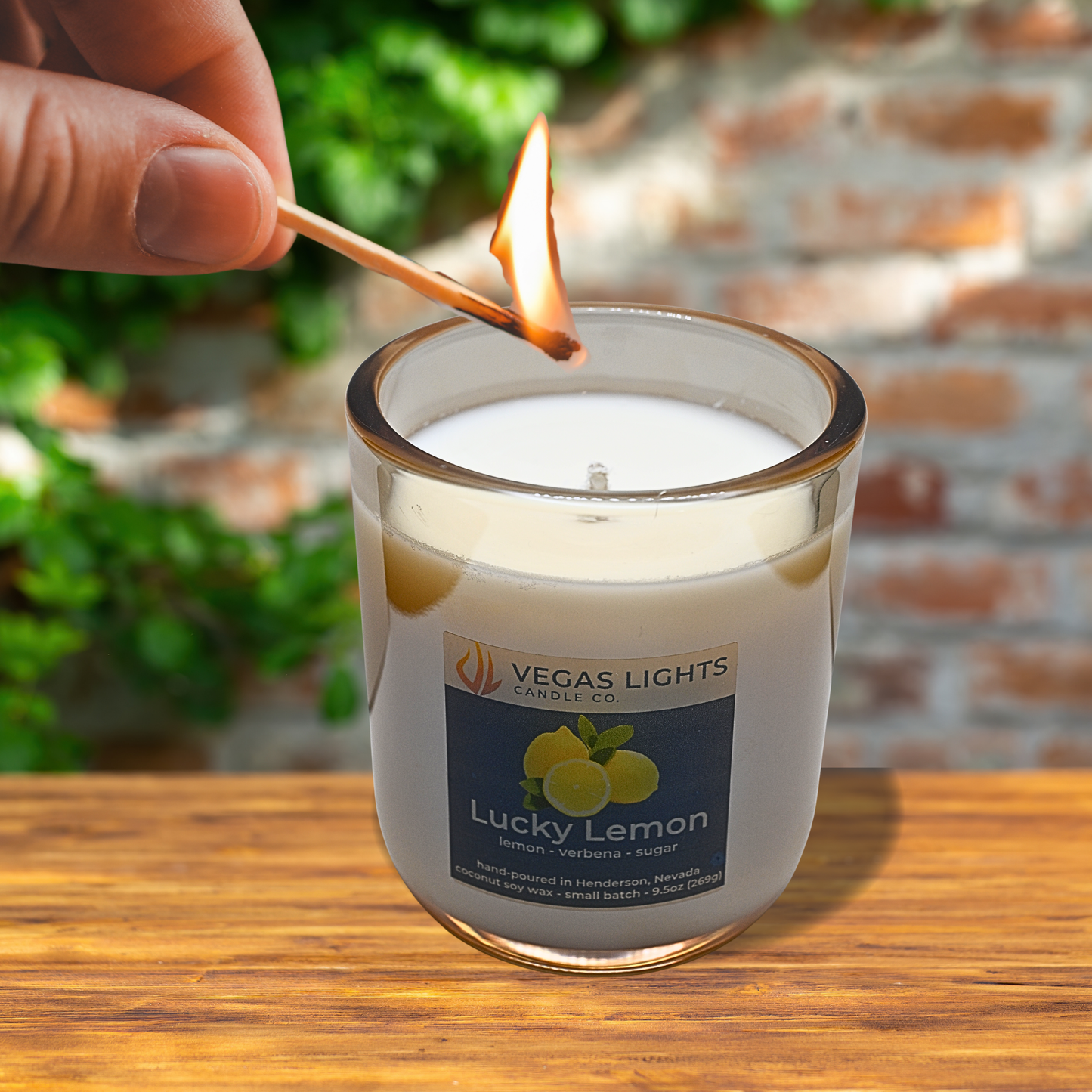 Candle being lit with a match, featuring 'Vegas Lights Lucky Lemon' label.