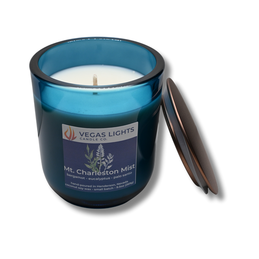 Blue candle jar with a white candle inside, featuring the Vegas Lights Candle Co. logo on a white background.