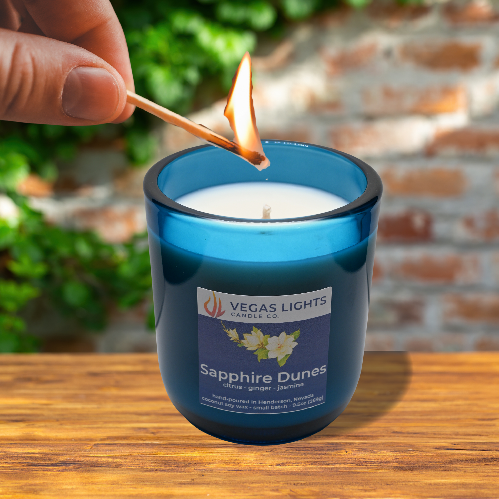 Vegas Lights Sapphire Dunes candle being lit with a match outdoors.